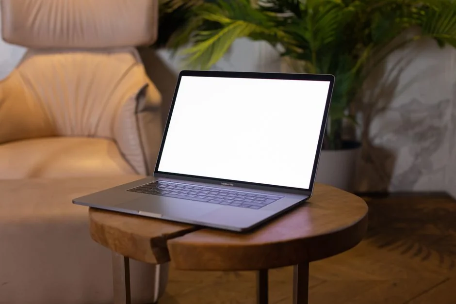 home-img A man is editing an image of fruit on a MacBook Pro while seated outside on the grass.
